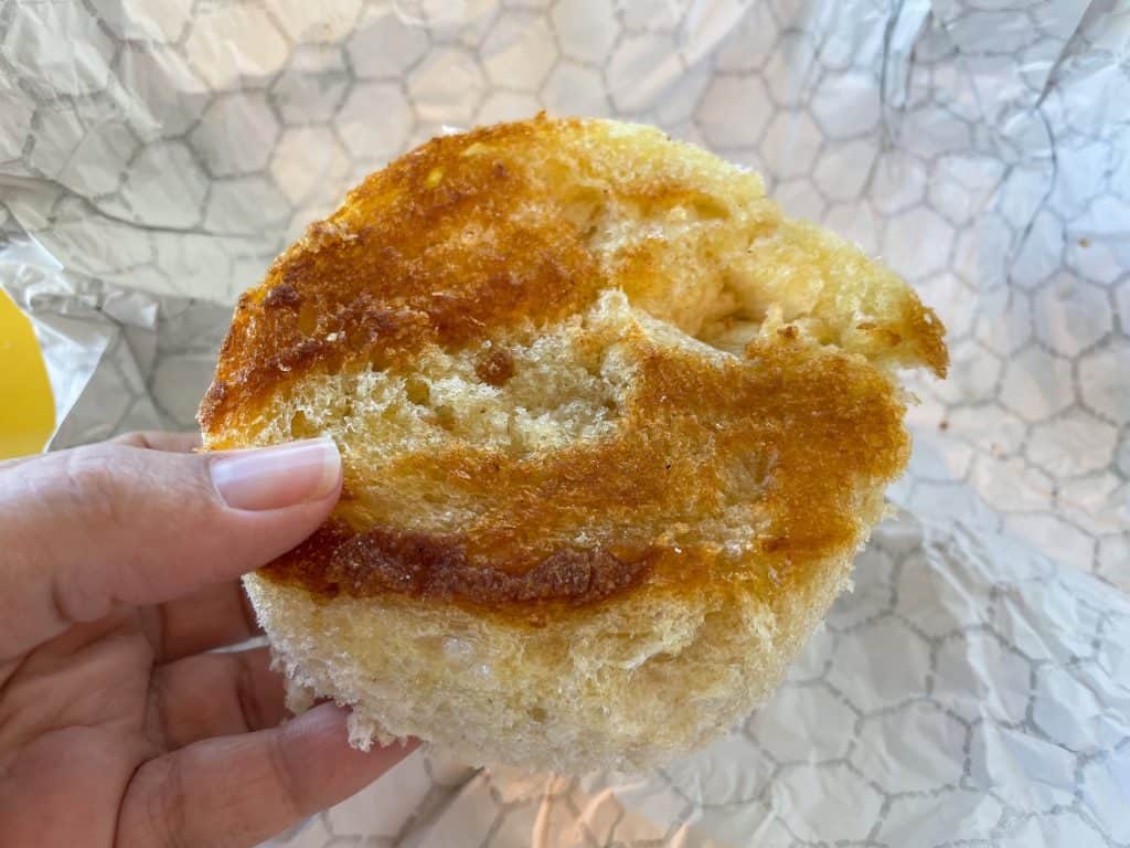 A round piece of bread from the center of the bread bowl that is toasted.