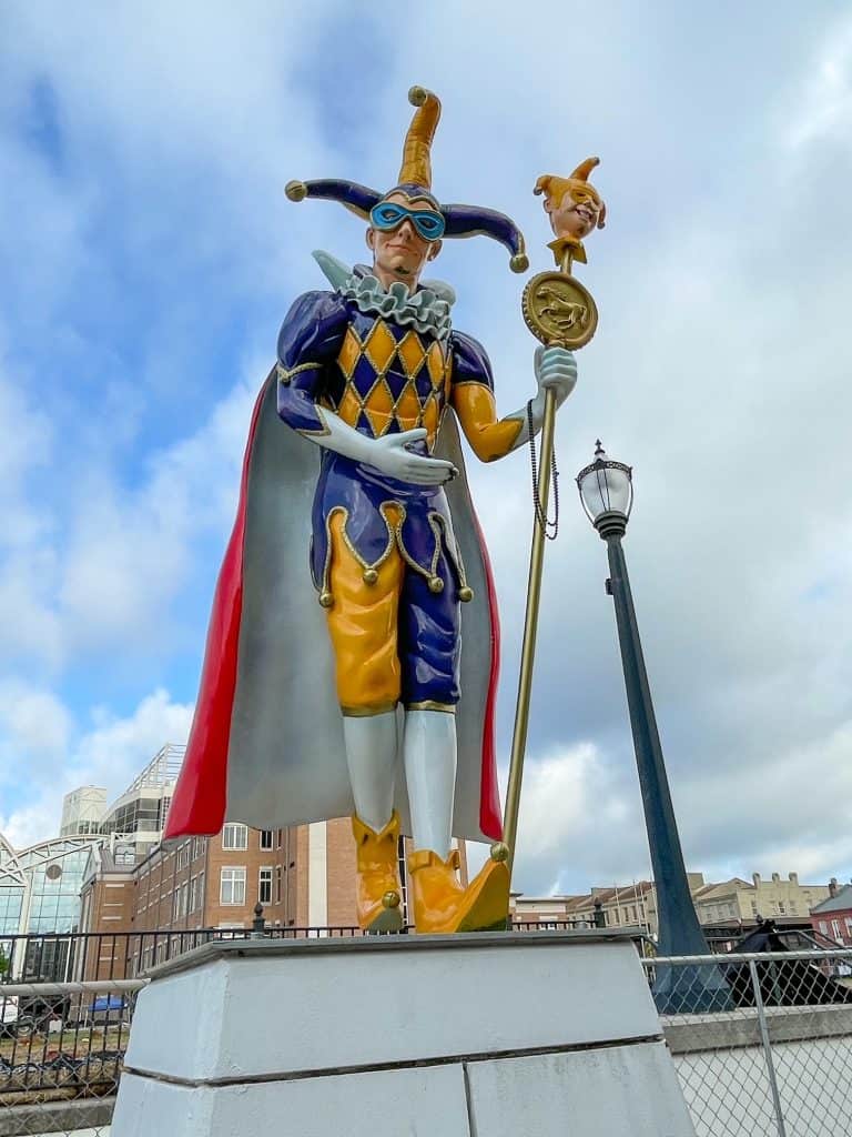 A statue dressed in costume resembling a jester for Mardi Gras celebration.
