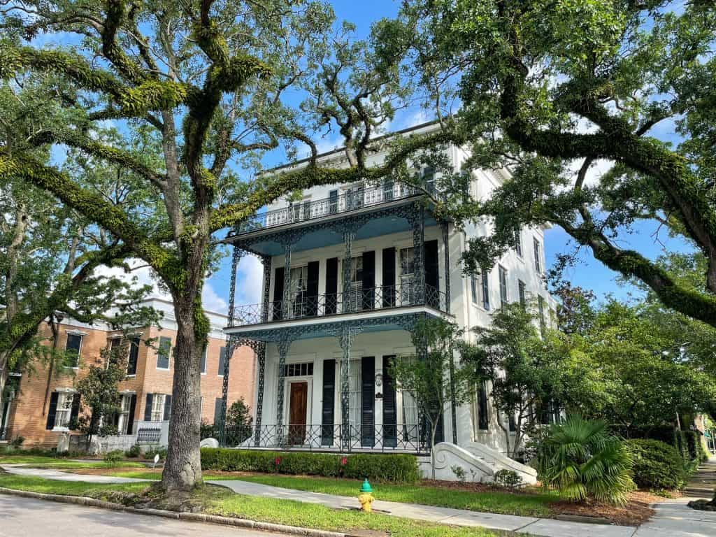 A charming historic house in De Tonti Square District of Mobile with a beautiful oak tree in front.