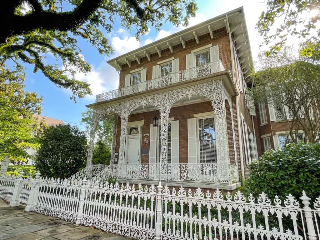 The tan colored Richards-Dar House Museum with white iron lace fence and balcony in De Tonti Historic District of Mobile.