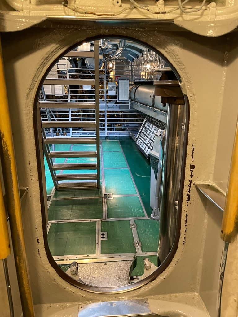 Crouching to walk through an oval door inside of the submarine to pass from one area to another.