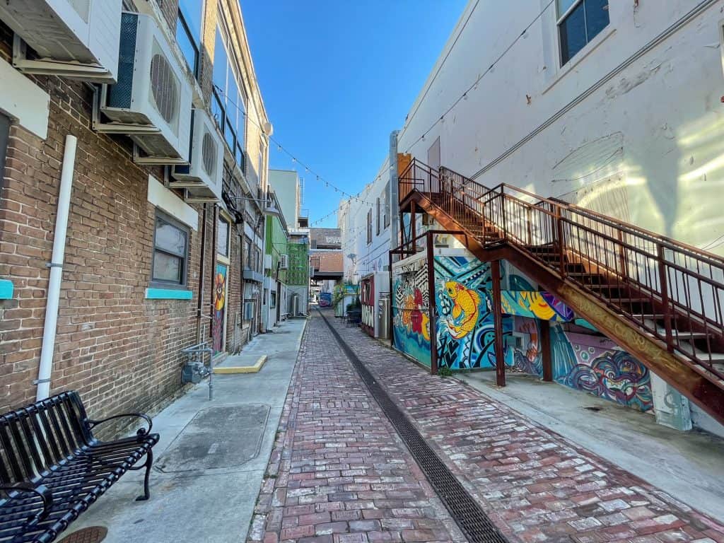 Wide view of the colorful art displays along the brick paved Fishbone Alley.