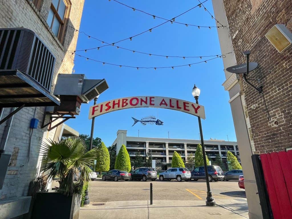 The Fishbone Alley sign up over the entrance to the alley with string of lights hanging in downtown Gulfport.