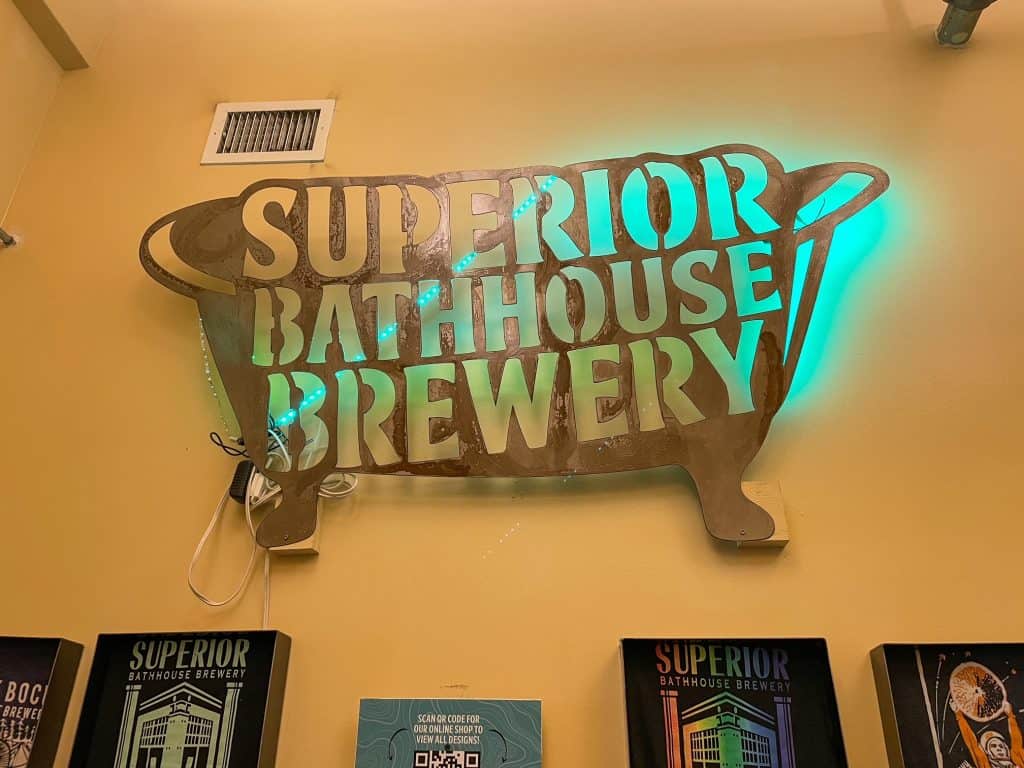 A sign for Superior Bathhouse Brewery shaped like a bathtub.