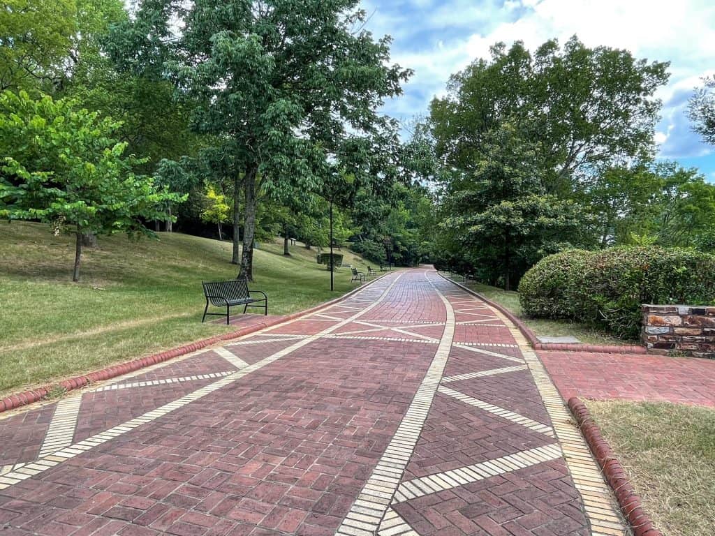 Walking along the brick paved Grand Promenade lined with lush trees in Hot Springs, AR.
