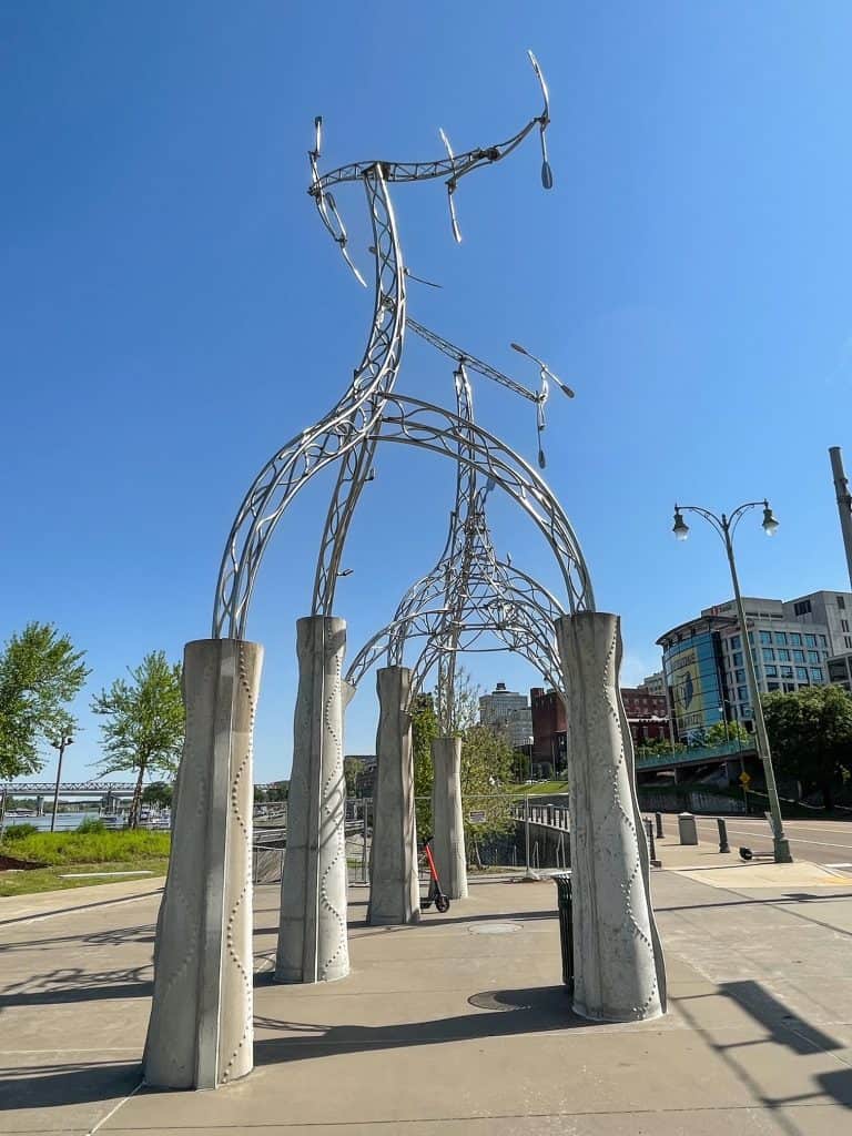 A tall and abstract metal piece of artwork along the riverfront of Memphis.