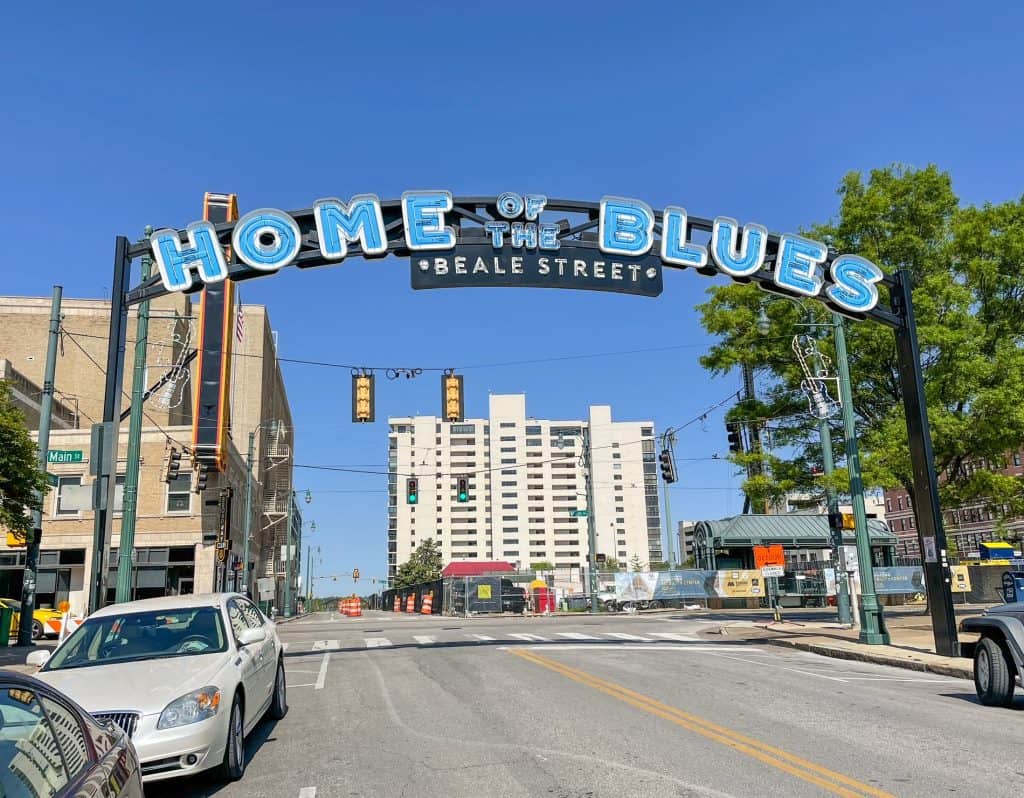 A huge sign that says " Home of the Blues - Beale Street" over the beginning of Beale Street in downtown Memphis.