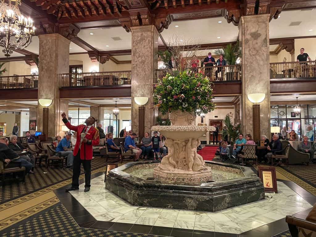 The ornate and grand lobby at the Peabody Hotel with the Duckmaster in a red coat explaining the history of the ducks.
