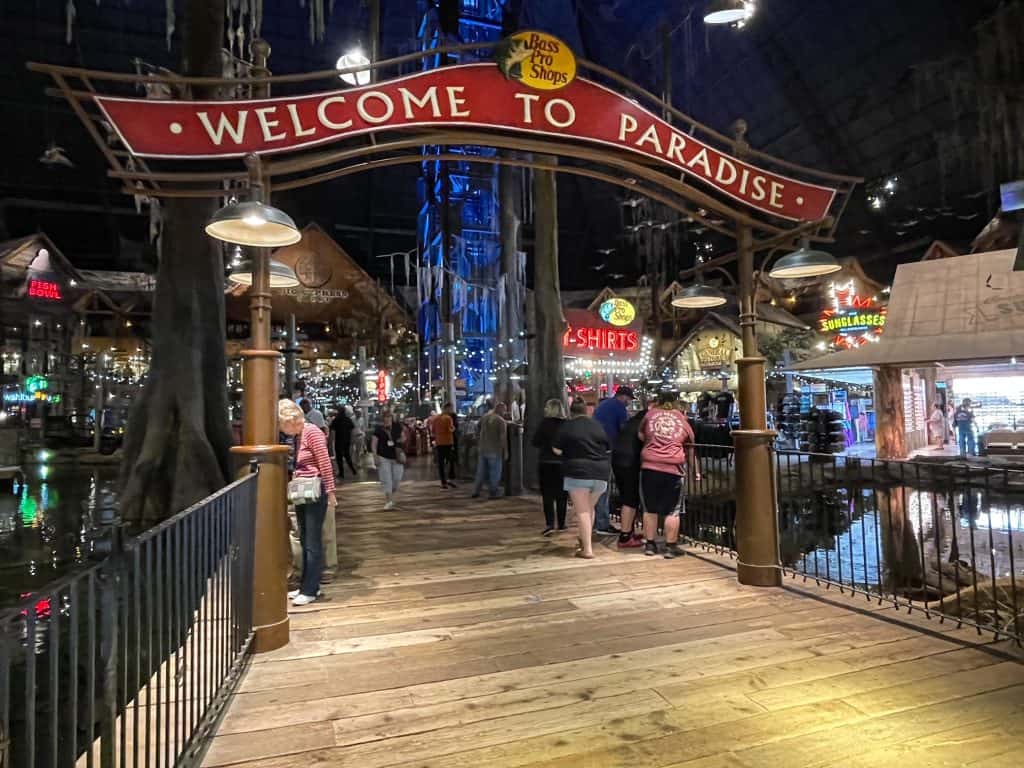Inside of Bass Pro Pyramid with a sign that says Welcome to Paradise walking through a boardwalk over the bayou.