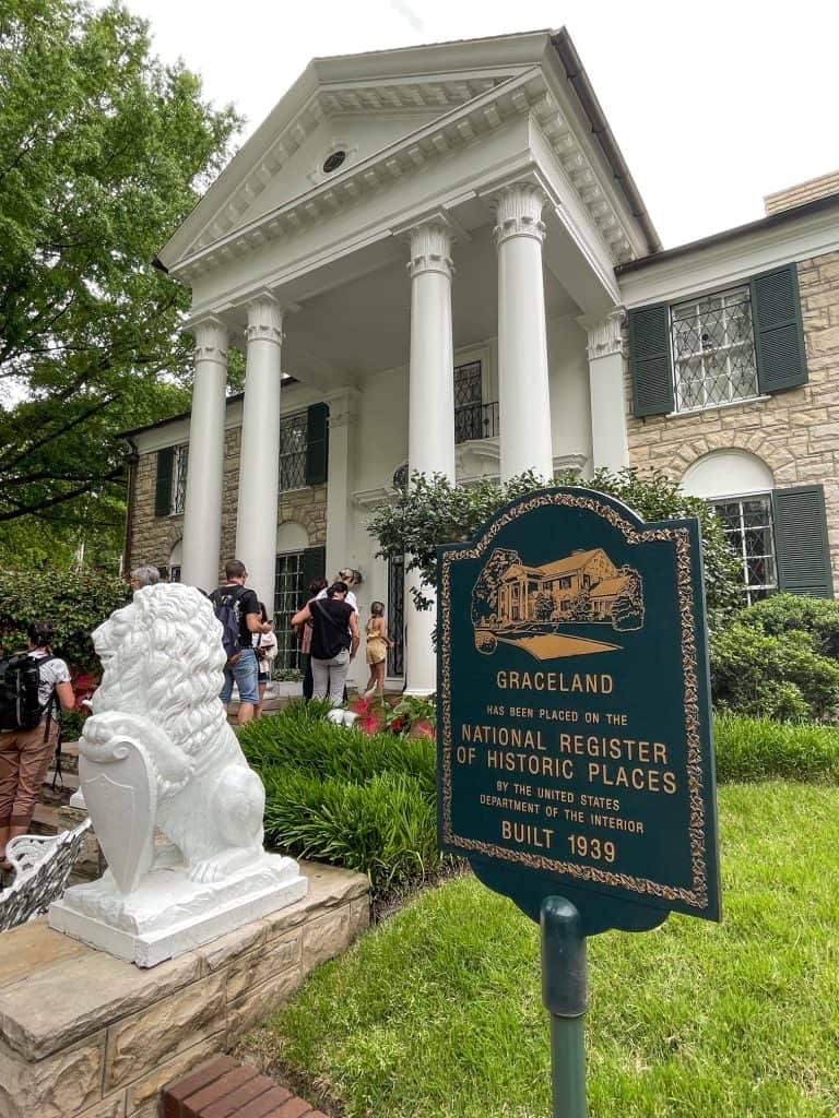 Front entrance to Elvis Presley's mansion with its tall columns and white lion statues walking up the steps as part of Graceland in Memphis.