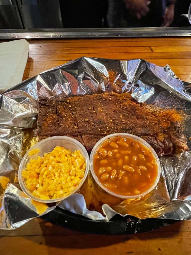 A small rack of pork ribs with a dry rub, a side of coleslaw and baked beans Memphis-style.