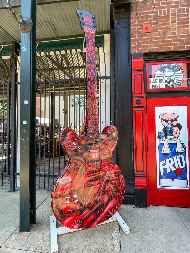 A red and black painted Gibson guitar statue on Beale Street in Memphis, TN.