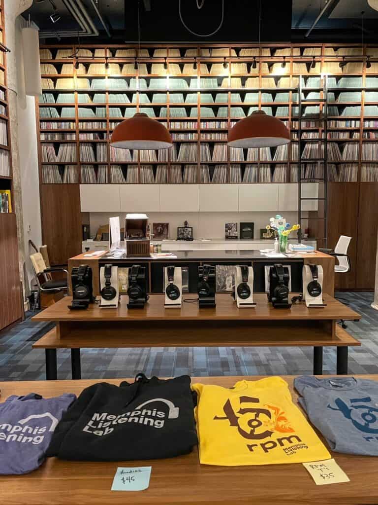 Inside the Memphis Listening Lab with shirts for sale, a row of headphones, and shelves of records.