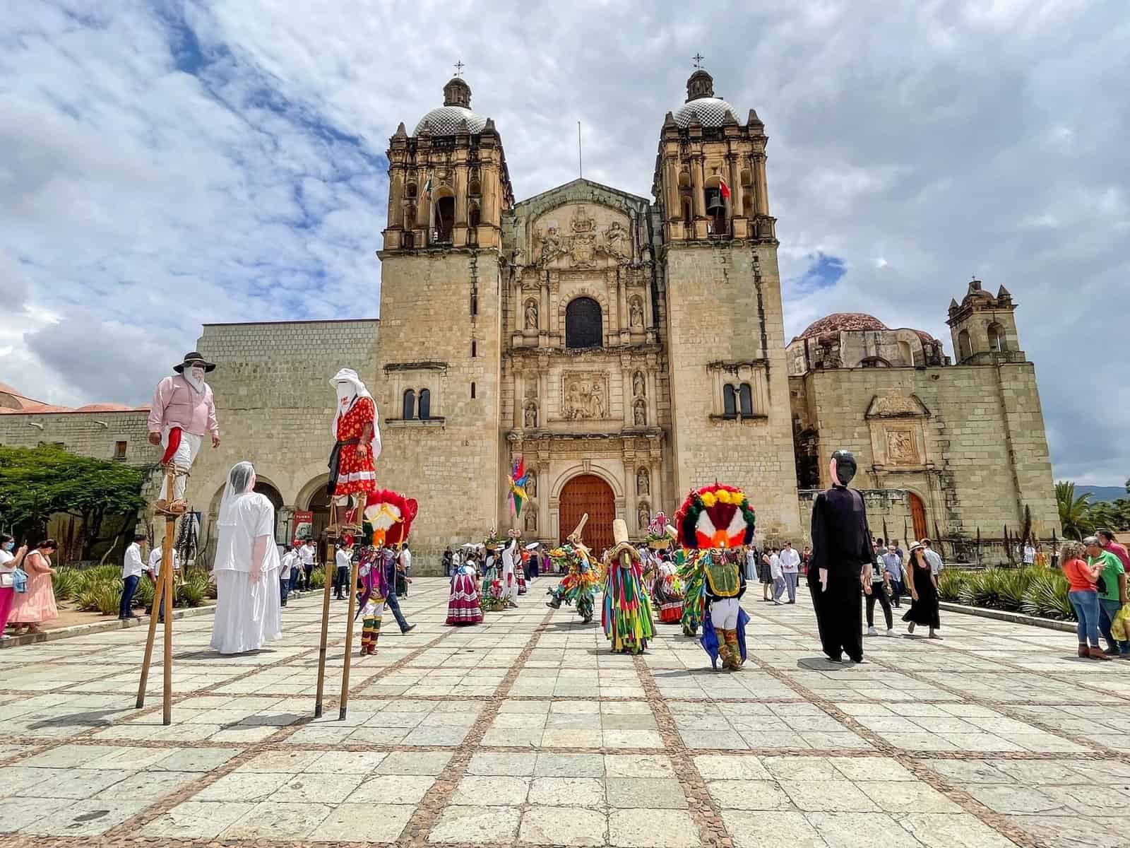 Standing in front of Templo de Santo Domingo with performers celebrating in front.