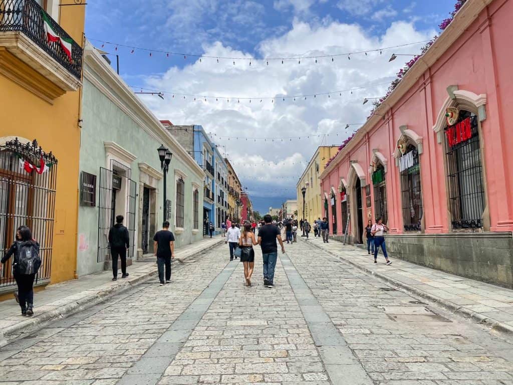 Walking down the charming pedestrian-only Calle Alcala with colorful buildings in downtown Oaxaca, Mexico.