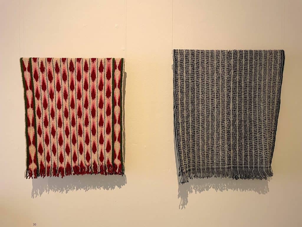 Two beautiful weaved blankets hanging, one in red and one in black colors at the Textile Museum in Oaxaca City.