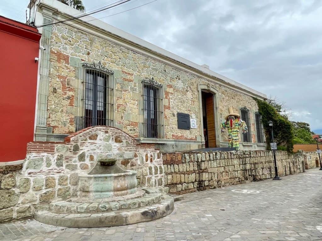The pretty front entrance to Hecho en Oaxaca with stone and a fountain.