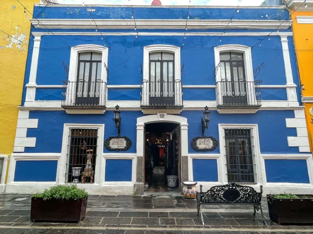 A beautiful historic royal blue building with white trim around windows and doors in Puebla City< Mexico.