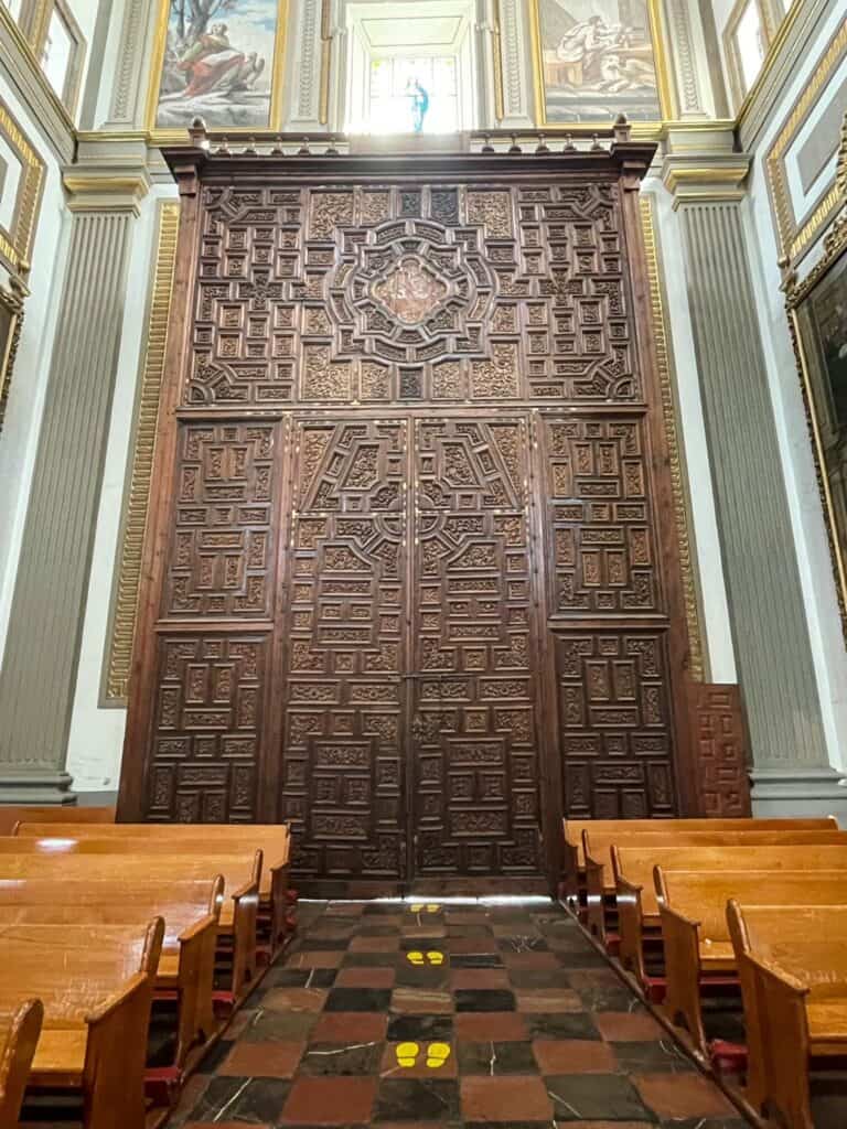 The inside view of the large center wooden door with exquisite craftsmanship in the carvings at Catedral de Puebla.