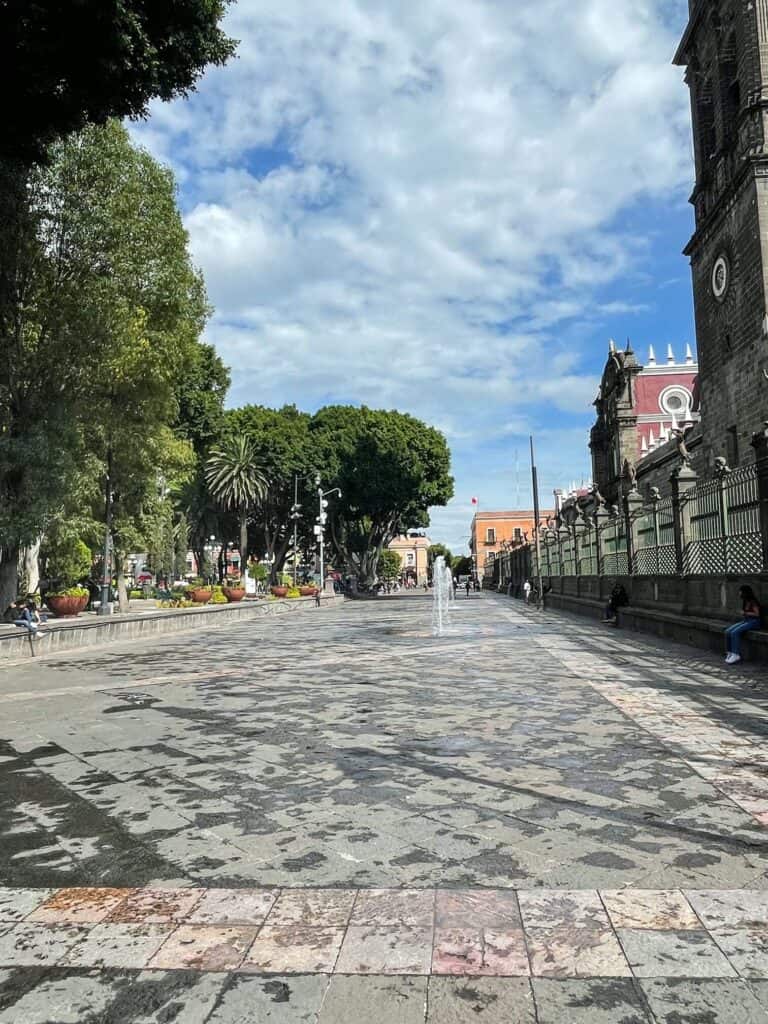 Walking down the wide open promenade with water fountains in Puebla's Zocalo.