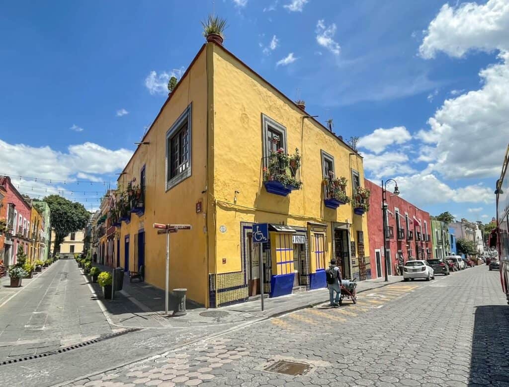 The bright pale yellow building on a corner that is home to La Pasita where you can enjoy a hot of Pasita liquor in Puebla, Mexico.