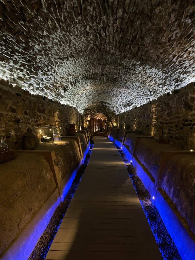 Walking further into the tunnels gets darker with pretty bright blue lighting along the walkway and a pale light overhead to see stone throughout.