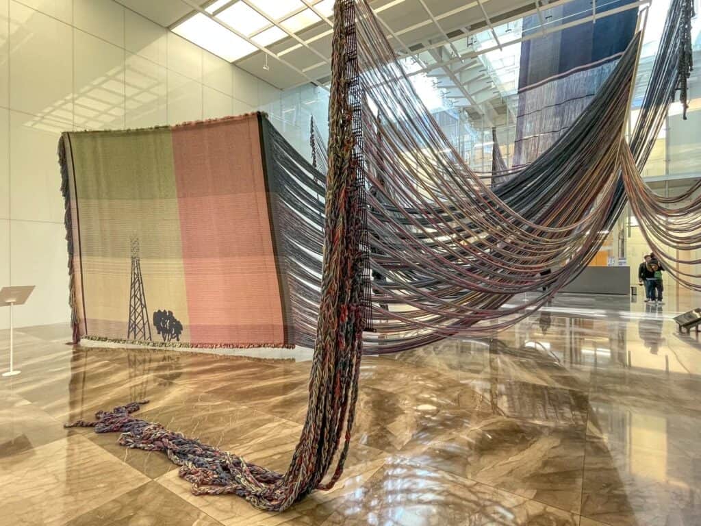 A huge and abstract textile weaving hanging from above when walking into Museo Amparo in Puebla, Mexico.