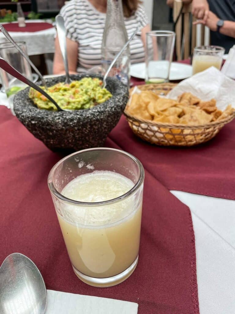 Chips and guacamole on a table with fresh squeezed juice at a restaurant on a food tour in San Miguel de Allende, Mexico.