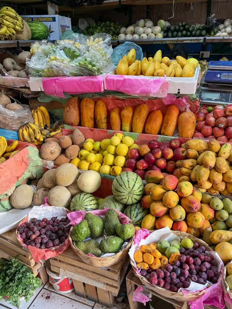 A vendor selling tons of produce in vibrant colors at the Ignacio Ramirez Market in San Miguel de Allende.