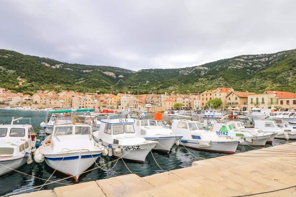 A row of small boats docked in a marina in the town of Komiza on Vis Island in Croatia's Adriatic Sea.
