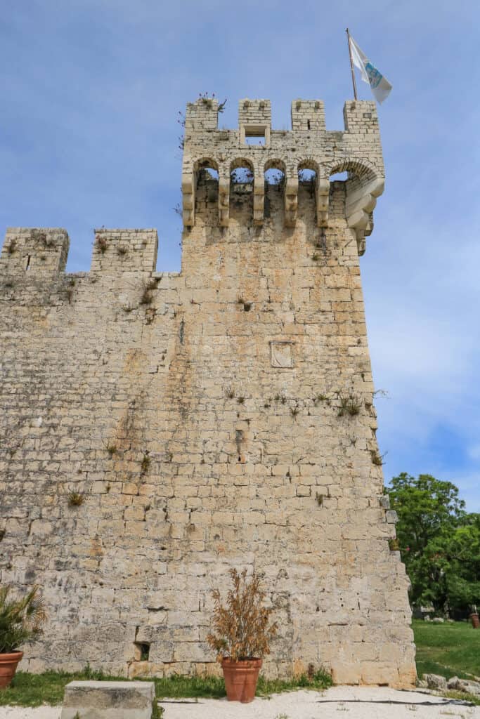 A vertical view of a stone tower at Kamerlengo Fortress on the charming island of Trogir, Croatia.
