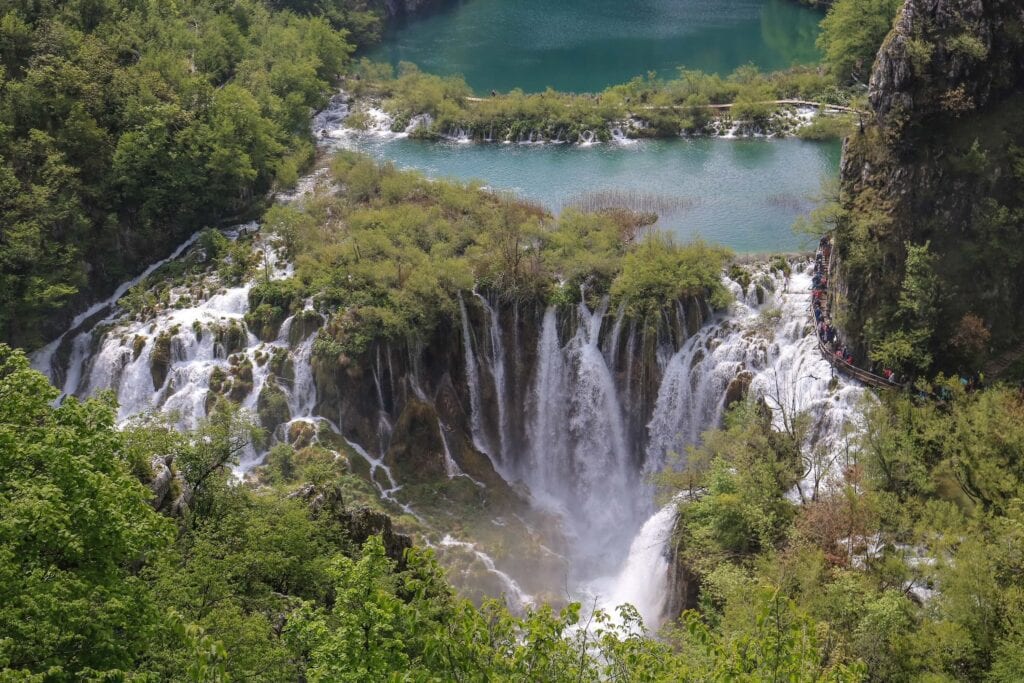Several breathtaking waterfalls cascading down from a lake at Plitvice Lakes National Park in Croatia.