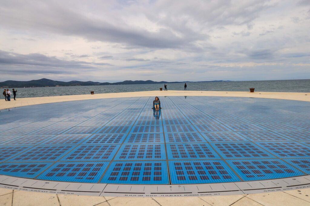 Sitting in the middle of a large blue circle made up of solar panels on the edge of the waterfront in Zadar, Croatia known as the Sun Salutation.