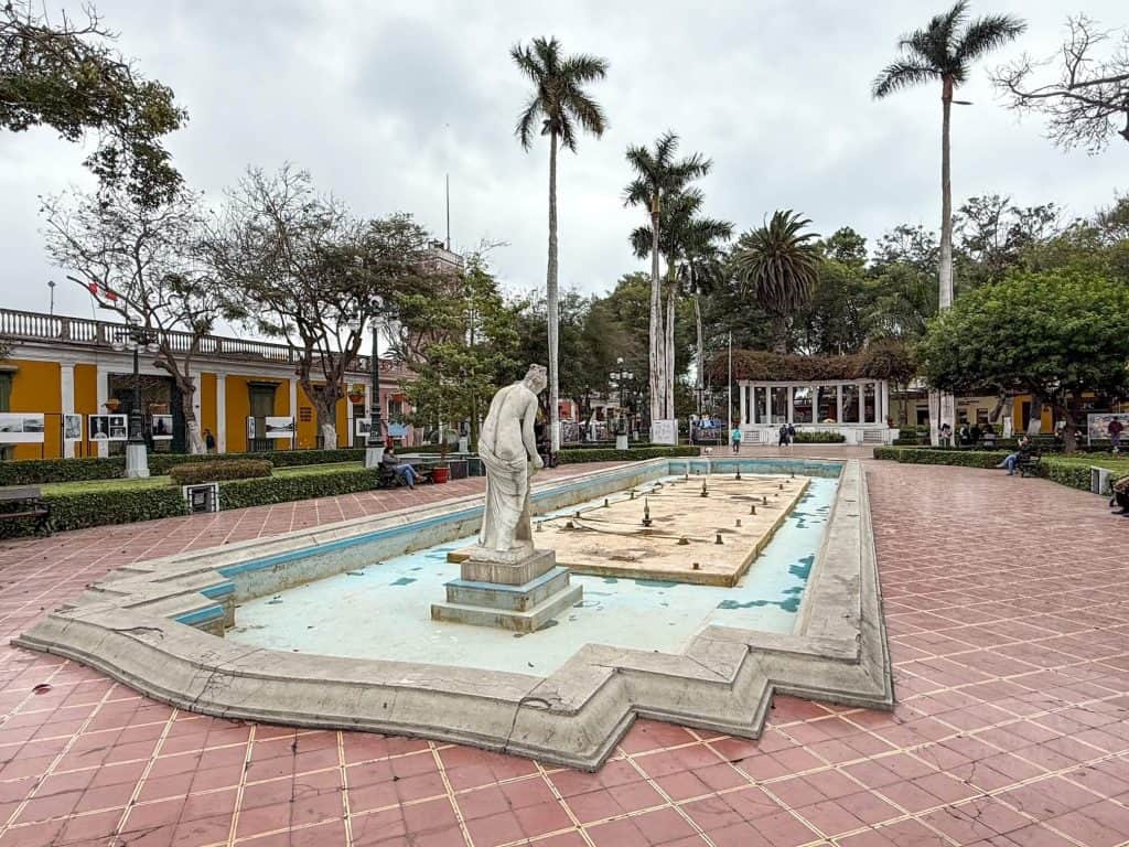 A long shallow fountain in the center of Municipal Park with a statue of Venus in the center in the Barranco neighborhood.