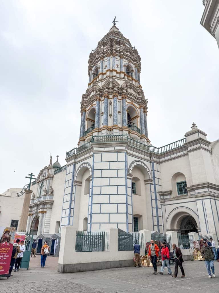 The bell tower of Santa Domingo Church with its cream colored tile with blue accents between tiles near the historic center of Lima, Peru.