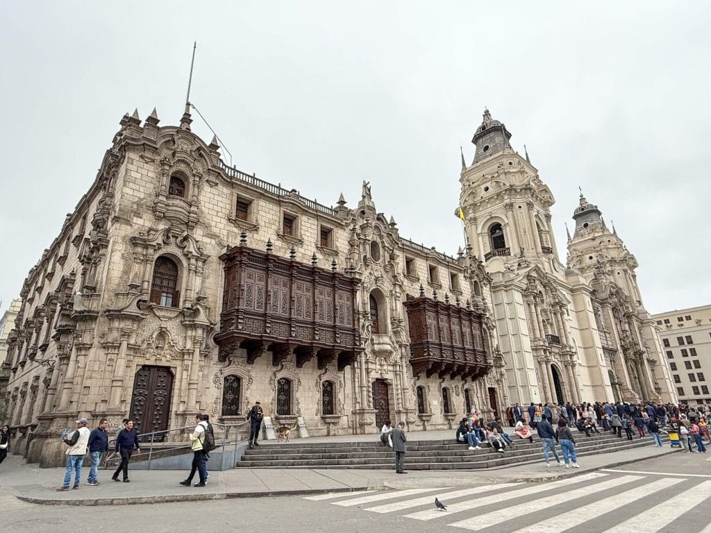 The beautiful historic building of the Archbishops Palace in Lima with its colonial architecture and wooden enclosed box balconies that extend out along the front facade next to Lima Cathedral.
