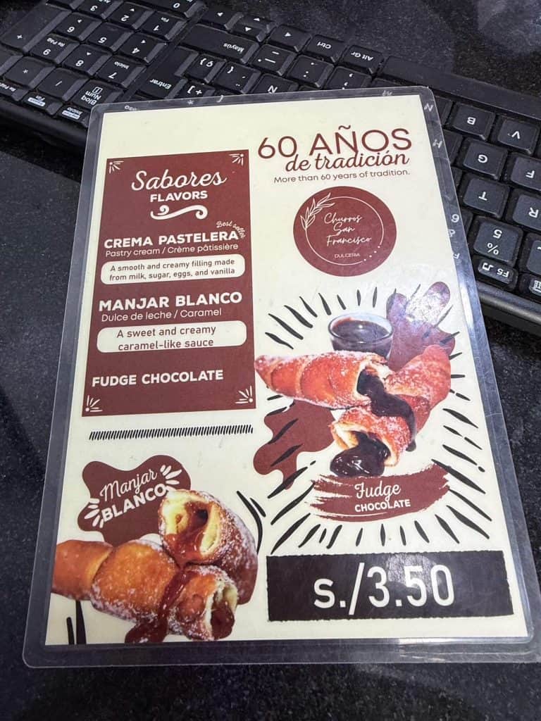A laminated menu at Churros San Francisco with 3 different filling options for churros, the best in Lima.