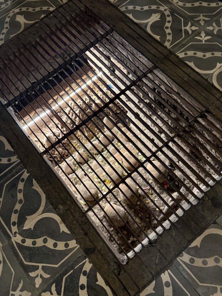 Looking down through a grate in the church floor with numerous skulls and bones of the catacombs below at San Francisco Church in Lima, Peru.