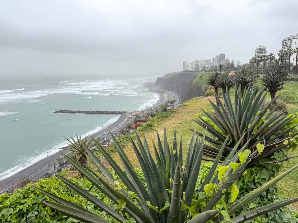 Looking down at the coast line in Lima with the Pacific Ocean on a cloudy overcast day from the walkway up on the cliffs known as the Malecon Miraflores.