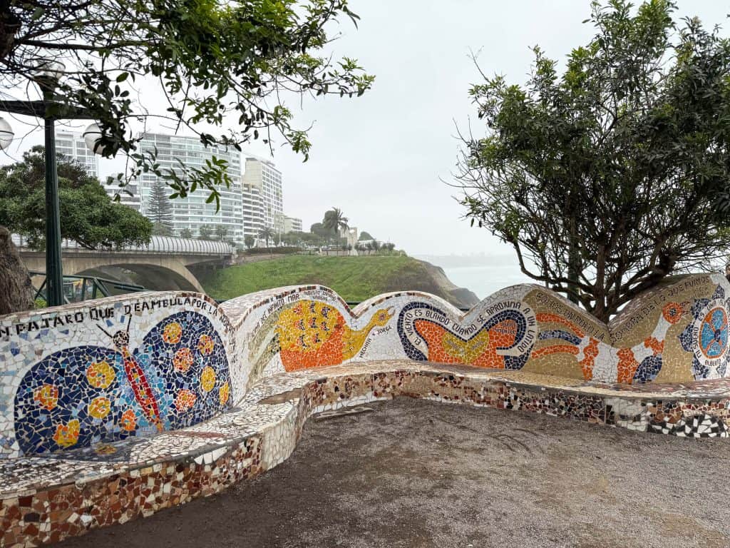The curving wall made of tiles in various colors creating images and quotes on the seating area of Love Park or Parque de Amor in Lima's Miraflores neighborhood.