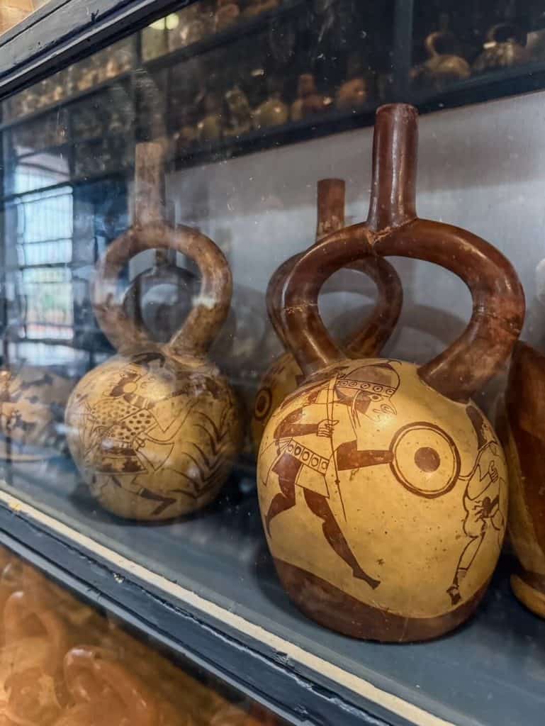 Several pre-Inca artifacts such as these hand held pots painted with indigenous people that don't look thousands of years old inside Museo Larco.