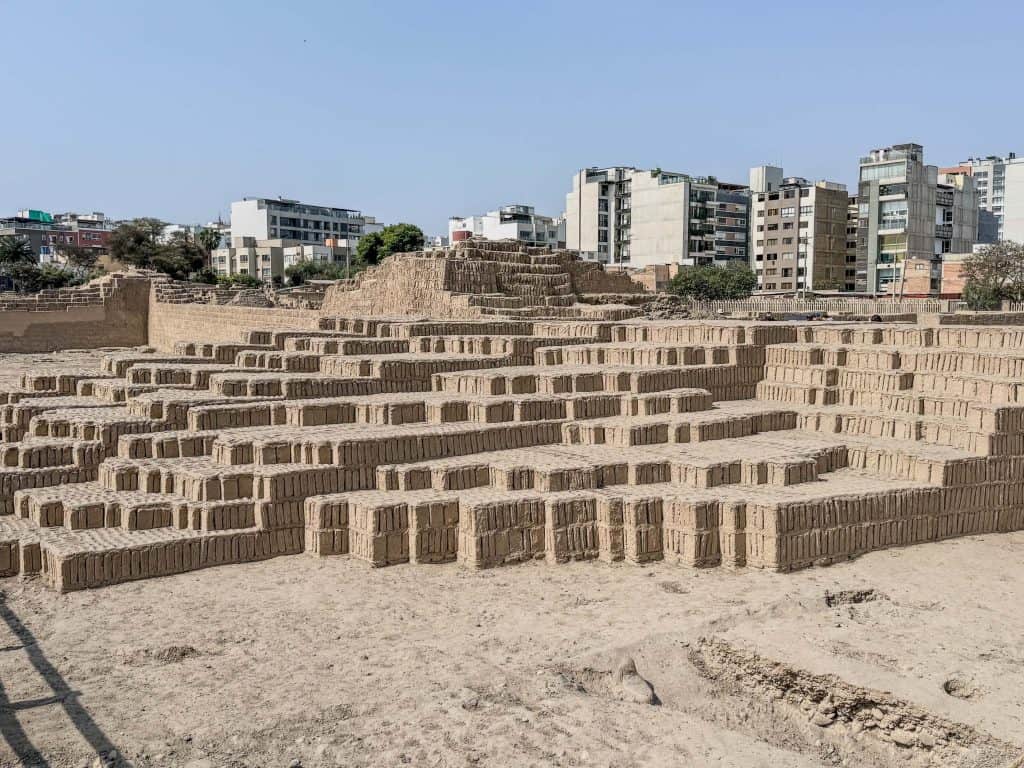 The pyramid ruins of Huaca Pucllana in the center of Lima with a series of layers or steps made out of clay and adobe bricks stacked in a library format.