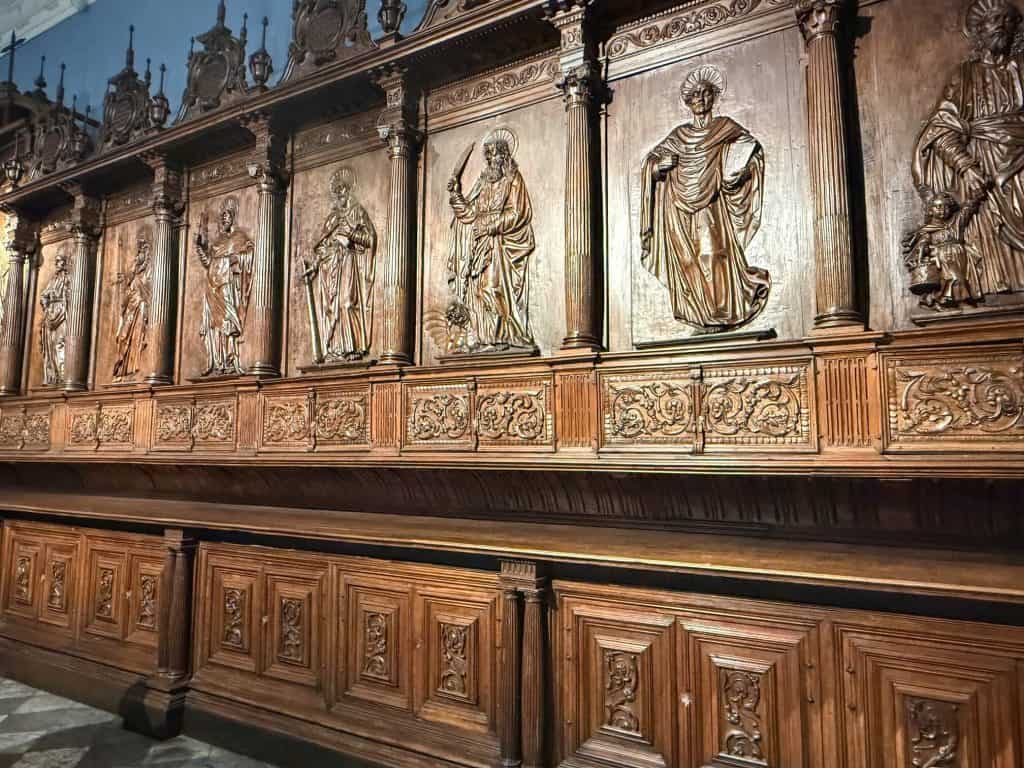 Close up view of the intricate carvings of figurines in wood paneling of the choir at Lima Cathedral.