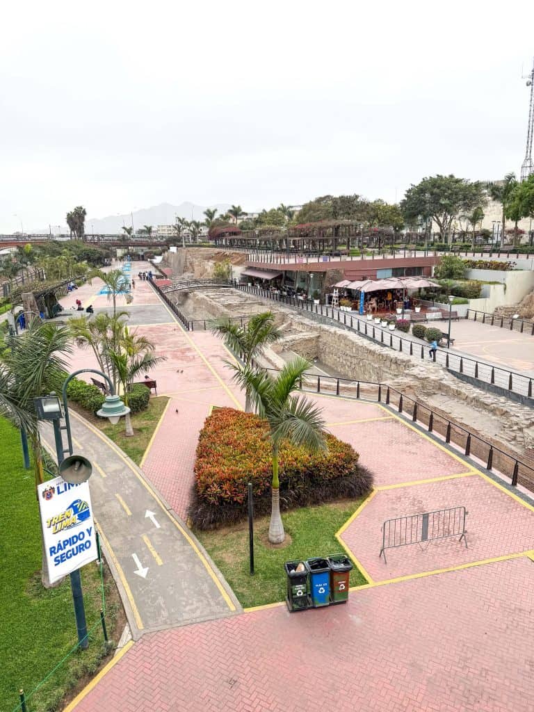 View of Parque de la Muralla with its green space and old wall ruins in Lima's historic district.