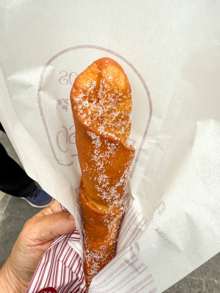 A thick rolled dough churro from Churros San Francisco filled with Manjar Blanco filling similar to caramel in Lima, Peru.
