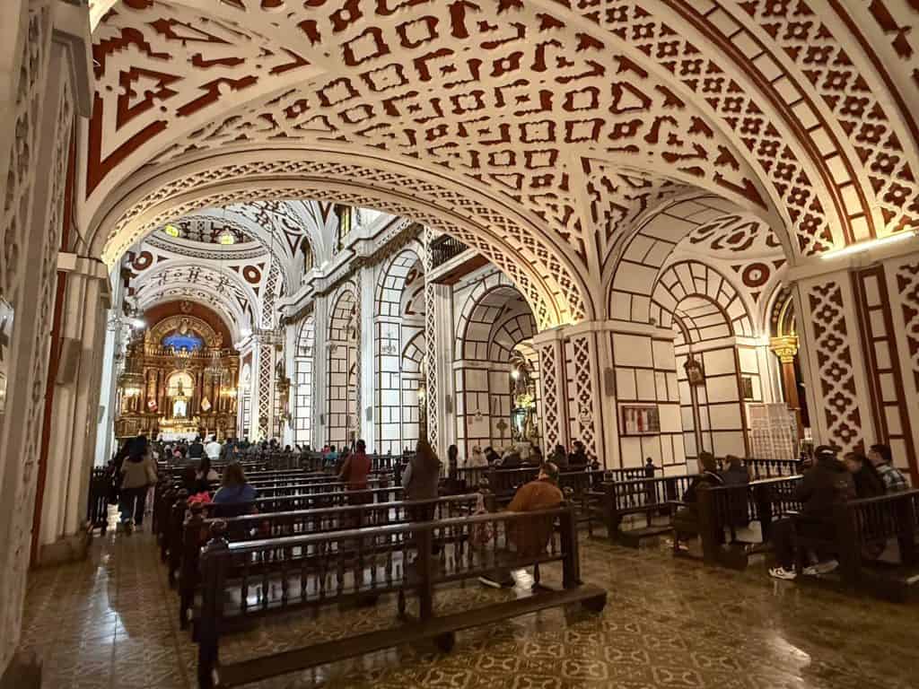 The beautiful interior of the cathedral at Convento San Francisco with its red and white patterned walls and ceiling in a Spanish-Moorish style of architecture.