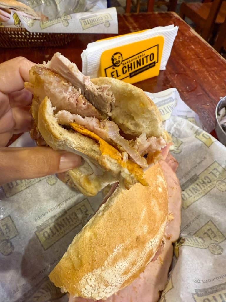 A chicharron sandwich, the best and most famous sandwich in the city at Sanguchería El Chinito in Lima.