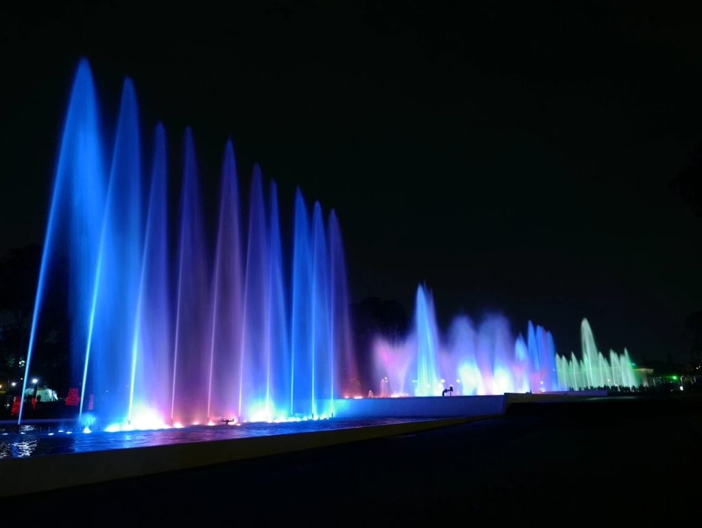 The series of water fountains lit up in shades of blue and purple at the Magic Water Circuit night show in Lima, Peru.